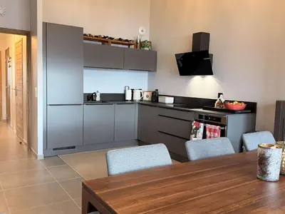 a kitchen with a table and chairs in a room at Appart neuf 3 ch 8 pers près patinoire avec balcon et parking - FR-1-572-347 in Arâches-la-Frasse