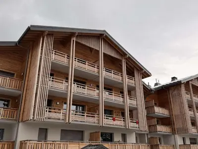 an apartment building with balconies on the side of it at Appart neuf 3 ch 8 pers près patinoire avec balcon et parking - FR-1-572-347 in Arâches-la-Frasse