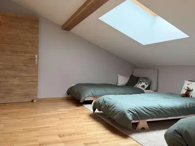 a attic bedroom with two beds and a skylight at Appart neuf 3 ch 8 pers près patinoire avec balcon et parking - FR-1-572-347 in Arâches-la-Frasse