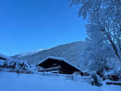 a house covered in snow next to a tree at Chalet Inouk 4 people Chamonix center in Chamonix-Mont-Blanc