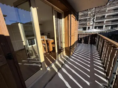 a balcony of a house with a glass door at Les Carroz - Rénové - Au cœur de la station - 4 pers in Arâches-la-Frasse
