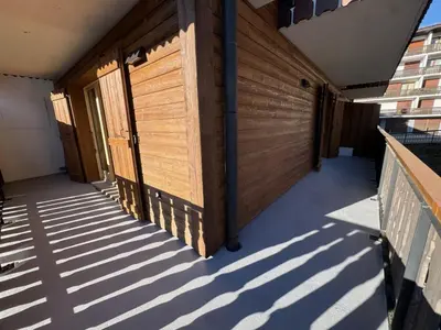 a row of wooden doors on the side of a building at Les Carroz - Rénové - Au cœur de la station - 4 pers in Arâches-la-Frasse