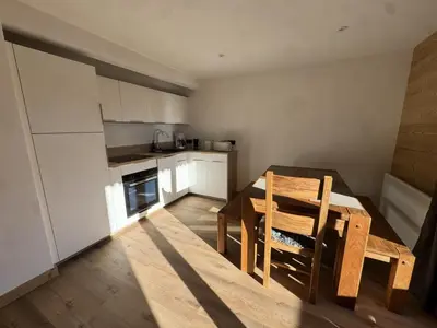 a kitchen with a table and a dining room at Les Carroz - Rénové - Au cœur de la station - 4 pers in Arâches-la-Frasse