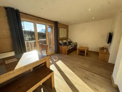 a living room with a large window and a couch at Les Carroz - Rénové - Au cœur de la station - 4 pers in Arâches-la-Frasse