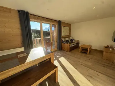 a living room with a large window and a bed at Les Carroz - Rénové - Au cœur de la station - 4 pers in Arâches-la-Frasse