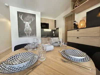 a dining room table with plates and glasses on it at Appartement cosy 2 pièces, terrasse, casier à skis, parking commun - FR-1-597-198 in Demi-Quartier