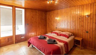 a bedroom with a bed with two hats on it at Appartement Le Daguet in Sallanches