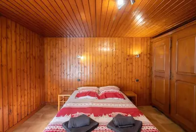 a bedroom with a bed in a wooden room at Appartement Le Daguet in Sallanches