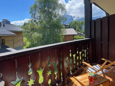 a balcony with a wooden railing with a table and a view at Duplex with fantastic view 3 bedrooms 7-9 pers in Arâches-la-Frasse
