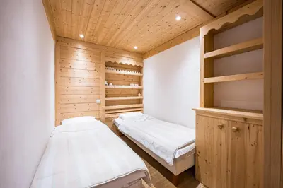 a bedroom with two beds and a wooden ceiling at L'Opale de Megève - station ski accessible à pied in Megève