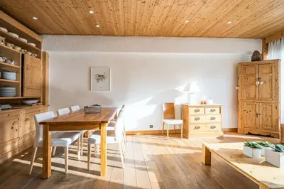 a dining room with a wooden table and chairs at L'Opale de Megève - station ski accessible à pied in Megève