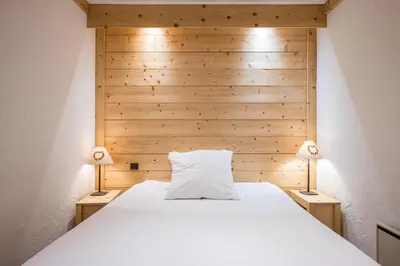 a bedroom with a white bed with two lamps at L'Opale de Megève - station ski accessible à pied in Megève