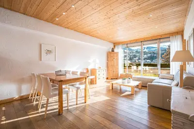 a living room with a table and a couch at L'Opale de Megève - station ski accessible à pied in Megève