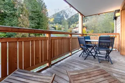 a wooden deck with chairs and a table on it at Bright apartment ideal in Les Houches for 4 in Les Houches