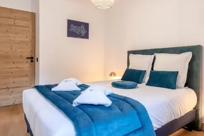 a bed with blue blankets and pillows on it at Bright apartment ideal in Les Houches for 4 in Les Houches