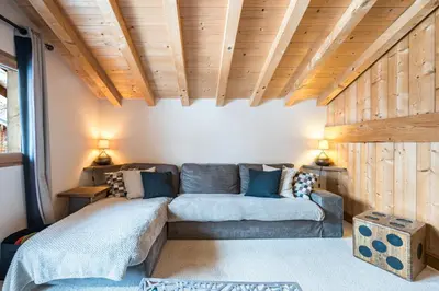 a living room with a couch and wooden ceilings at Chalet Etelley - Jacuzzi Privé in Samoëns