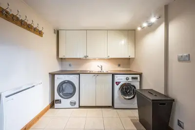 a kitchen with a washing machine and a washer at Chalet Etelley - Jacuzzi Privé in Samoëns