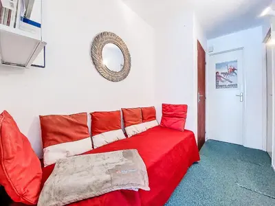 a red couch in a room with a mirror at Apartment Topaze-2 by Interhome in Saint-Gervais-les-Bains