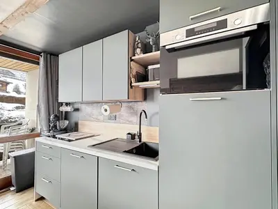 a white kitchen with a sink and a refrigerator at PLA233 - Studio neuf 4 pers centre village in Les Carroz d'Araches