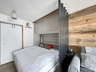 a bedroom with a bed and a wooden wall at PLA233 - Studio neuf 4 pers centre village in Les Carroz d'Araches