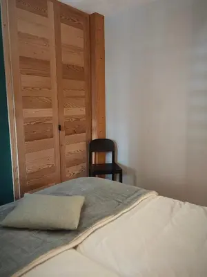 a bedroom with a bed with a wooden door and a chair at Soleil in Chamonix-Mont-Blanc