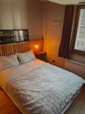 a bedroom with a large bed with a wooden headboard at Soleil in Chamonix-Mont-Blanc