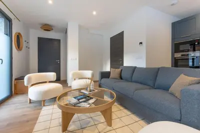 a living room with a blue couch and a table at Babotches - Chalet 110m2 Moderne Familial 7 pax in Chamonix-Mont-Blanc