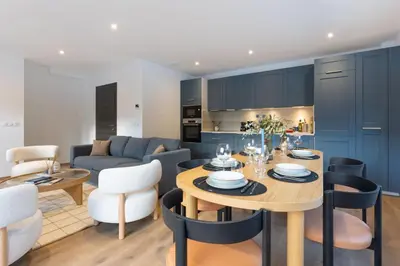 a kitchen and living room with a table and chairs at Babotches - Chalet 110m2 Moderne Familial 7 pax in Chamonix-Mont-Blanc