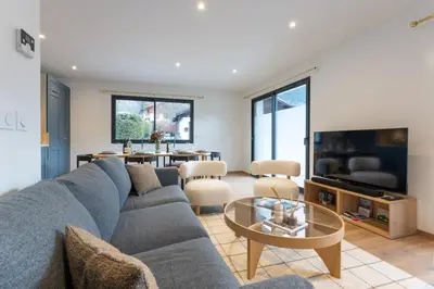 a living room with a blue couch and a table at Babotches - Chalet 110m2 Moderne Familial 7 pax in Chamonix-Mont-Blanc