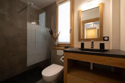 a bedroom with a large bed and a window at Repos du Loup - Chalet 4CH 4SDB Jacuzzi BainNordique in Chamonix-Mont-Blanc