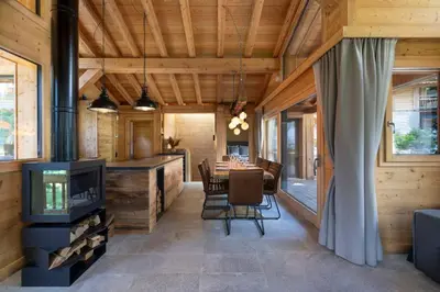 a dining room with a fireplace and a dining table at Repos du Loup - Chalet 4CH 4SDB Jacuzzi BainNordique in Chamonix-Mont-Blanc