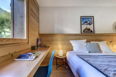 a bedroom with a bed and a table and a desk at Lyret - Moderne 2CH 2SDB Vue MtBlanc 250m Remontee in Les Houches