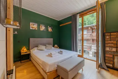 a bedroom with a white bed and a green wall at Straton - Cosy 1 CH Modern Hypercentre Transport 150m in Chamonix-Mont-Blanc