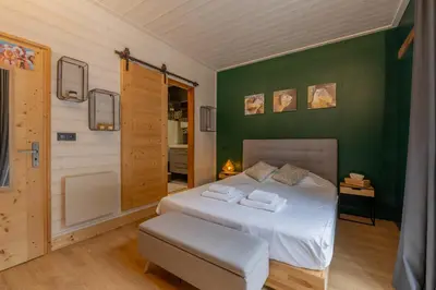 a bedroom with a white bed and a green wall at Straton - Cosy 1 CH Modern Hypercentre Transport 150m in Chamonix-Mont-Blanc