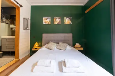 a bedroom with a white bed with green walls at Straton - Cosy 1 CH Modern Hypercentre Transport 150m in Chamonix-Mont-Blanc