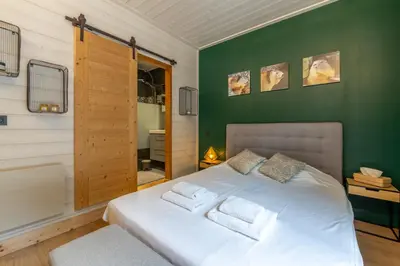a bedroom with a white bed with a green wall at Straton - Cosy 1 CH Modern Hypercentre Transport 150m in Chamonix-Mont-Blanc
