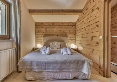 a bedroom with a bed with a wooden wall at Clairtemps- Charmant Chalet 168 m2 6 Pax Familial Vue in Les Houches
