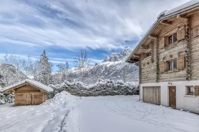 a log cabin in the snow next to a driveway at Clairtemps- Charmant Chalet 168 m2 6 Pax Familial Vue in Les Houches