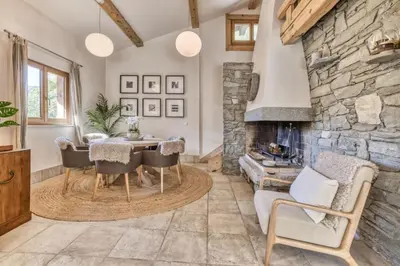 a living room with a stone fireplace and a table and chairs at Clairtemps- Charmant Chalet 168 m2 6 Pax Familial Vue in Les Houches