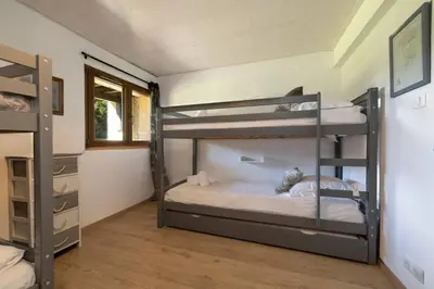 a bedroom with two bunk beds in a room at Les Iles - Chalet 165m2 Vue Mont Familial 10 pax in Chamonix-Mont-Blanc