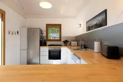 a kitchen with white cabinets and a refrigerator at Les Iles - Chalet 165m2 Vue Mont Familial 10 pax in Chamonix-Mont-Blanc