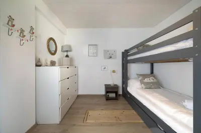 a bedroom with a bunk bed and a dresser at Les Iles - Chalet 165m2 Vue Mont Familial 10 pax in Chamonix-Mont-Blanc