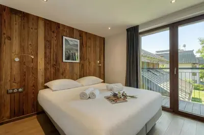 a bedroom with a large bed and a large window at Modern Luxury Chalet BADI with Sauna - Happy Rentals in Chamonix-Mont-Blanc