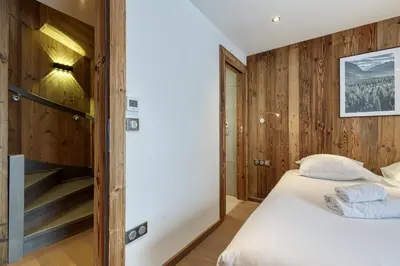 a bedroom with a bed and wooden walls at Modern Luxury Chalet BADI with Sauna - Happy Rentals in Chamonix-Mont-Blanc
