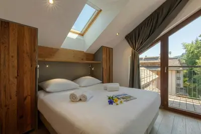a bedroom with a white bed with a large window at Modern Luxury Chalet BADI with Sauna - Happy Rentals in Chamonix-Mont-Blanc