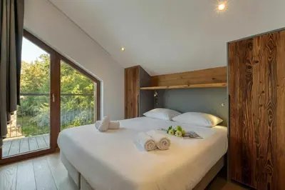a bedroom with a large bed with a large window at Modern Luxury Chalet BADI with Sauna - Happy Rentals in Chamonix-Mont-Blanc