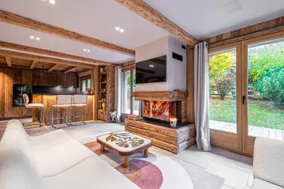 a living room with a fireplace and a tv at Superb Chalet Isatis-renovated in Megeve in Megève