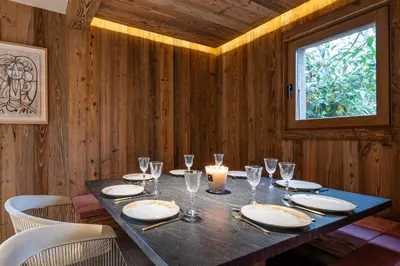 a dining table with a candle and wine glasses at Superb Chalet Isatis-renovated in Megeve in Megève
