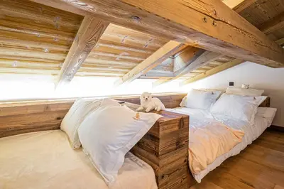 a large bed in a room with wooden ceilings at Superb Chalet Isatis-renovated in Megeve in Megève