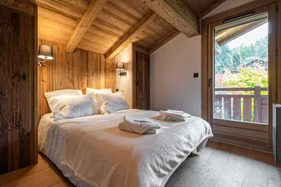 a bedroom with a bed with two towels on it at Superb Chalet Isatis-renovated in Megeve in Megève